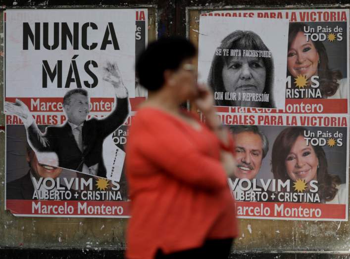 A woman stands near a wall covered in election posters one day after of the inauguration of Argentina's President Alberto Fernandez and his Vice President Cristina Fernandez de Kirchner in Buenos Aires, Argentina December 11, 2019. REUTERS/Ueslei Marcelin