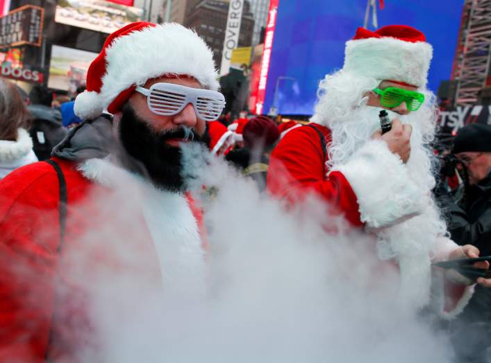 Revelers dressed as Santa Claus vape as they take part in the event called SantaCon at Times Square in New York City, U.S., December 14, 2019. REUTERS/Eduardo Munoz TPX IMAGES OF THE DAY