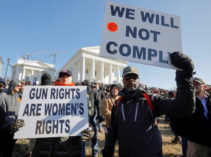 Gun rights advocates hold signs during a rally inside the no-gun zone in front of the Virginia State Capitol building in Richmond, Virginia, U.S. January 20, 2020. REUTERS/Jonathan Drake