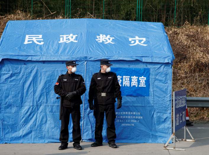 Security personnel stand in front of a disaster relief tent at a checkpoint in Yunxi county, Hunan province, near the border to Hubei province, on virtual lockdown after an outbreak of a new coronavirus, in China, January 28, 2020. REUTERS/Thomas Peter