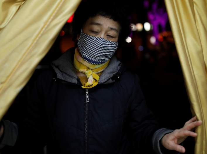 A woman wearing a face mask enters a supermarket, as the country is hit by an outbreak of the new coronavirus, in Beijing, China January 31, 2020. REUTERS/Carlos Garcia Rawlins