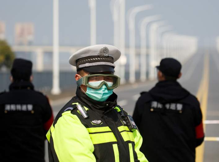 A police officer wears a face mask and goggles at a checkpoint at the Jiujiang Yangtze River Bridge as the country is hit by an outbreak of the novel coronavirus in Jiujiang, Jiangxi province, China, February 4, 2020. REUTERS/Thomas Peter