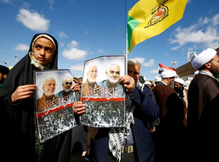 Iranian people carry pictures of the late Iran's Quds Force top commander Qassem Soleimani and Iraqi militia commander Abu Mahdi al-Muhandis, who were killed in a U.S. airstrike at Baghdad airport, during the forty days memorial at the "Valley of Peace" c