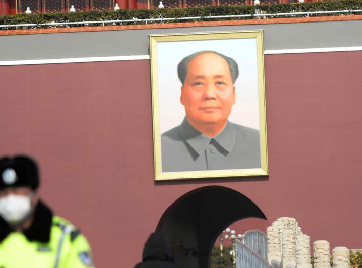 A police officer wearing a face mask stands guard under a giant portrait of the late Chinese chairman Mao Zedong at the Tiananmen Gate as the country is hit by an outbreak of the novel coronavirus, in Beijing, China February 19, 2020. REUTERS/Tingshu Wang