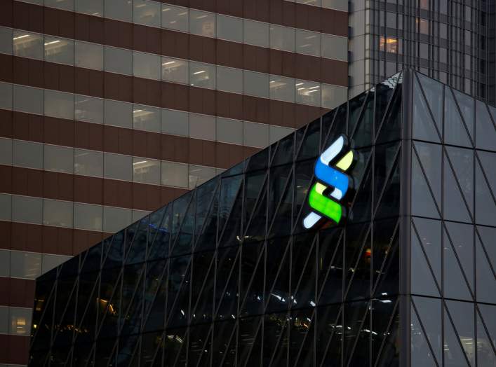 FILE PHOTO: A logo of Standard Chartered is displayed at the financial Central district in Hong Kong, China November 23, 2017. REUTERS/Bobby Yip/File Photo GLOBAL BUSINESS WEEK AHEAD