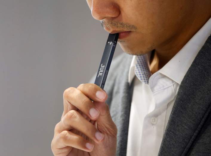 A shopkeeper demonstrates smoking a Juul brand vaping pen to customers at a Juul shop in Jakarta, Indonesia, December 30, 2019. Picture taken December 30, 2019. REUTERS/Ajeng Dinar Ulfiana