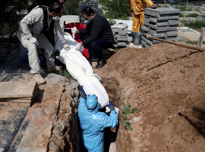 Iranian men bury the journalist Abdollah Zavieh, who passed away due to coronavirus disease (COVID-19), at Behesht Zahra cemetery in Tehran, Iran, March 24, 2020. WANA (West Asia News Agency)/Ali Khara via REUTERS