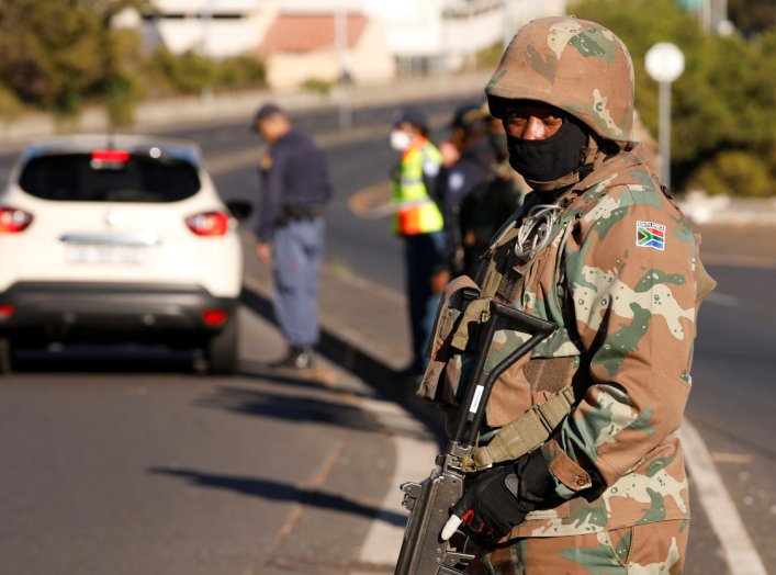 A soldier stands guard as he is joined by police officers to check vehicles as a 21-day lockdown aimed at limiting the spread of coronavirus disease (COVID-19) takes effect in Cape Town, South Africa, March 27,2020.REUTERS/Mike Hutchings