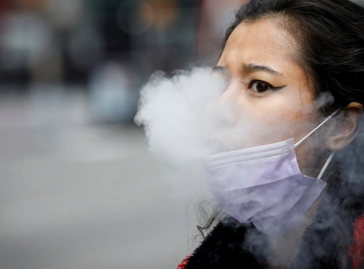 A woman exhales after vaping in Times Square, during the coronavirus disease (COVID-19) outbreak, in New York City, U.S., March 31, 2020. REUTERS/Brendan McDermid