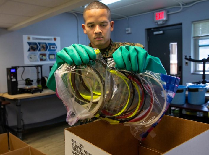 U.S. Marine Corps Cpl. Michael Espinosa packs 3-D printed face masks for health workers treating coronavirus disease (COVID-19) into a box at Camp Lejeune, North Carolina, U.S. March 30, 2020. Picture taken March 30, 2020. U.S. Marine Corps/Lance Cpl. Sco