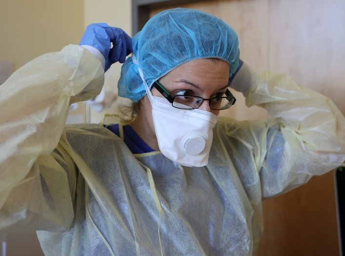 A member of the medical staff adjusts her face mask before treating a patient suffering from the coronavirus disease (COVID-19) in an intensive care unit at Havelhoehe community hospital in Berlin, Germany, April 6, 2020. REUTERS/Fabrizio Bensch