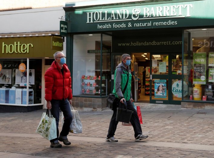 People wearing protective face masks are seen outside a Holland & Barrett store in Durham, as the spread of the coronavirus disease (COVID-19) continues, Durham, Britain, April 8, 2020. REUTERS/Lee Smith