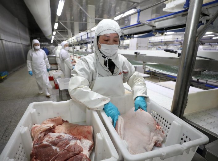 Employees work at a pig slaughtering and pork processing plant in Huaian, Jiangsu province, China April 9, 2020. Picture taken April 9, 2020. China Daily via REUTERS