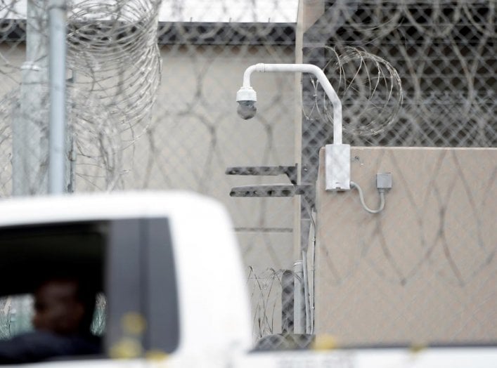 A prison employee drives past a surveillance camera on the grounds of the Otay Mesa Detention Center, a ICE (Immigrations & Customs Enforcement) federal detention center privately owned and operated by prison contractor CoreCivic, amid the coronavirus dis