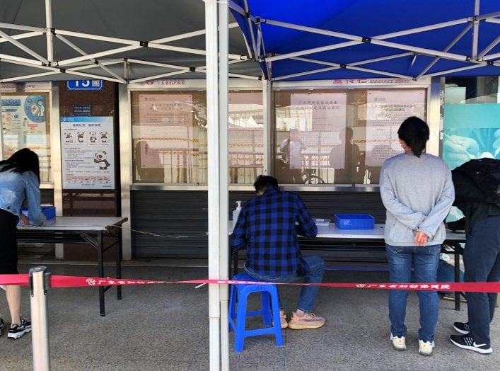 Residents fill out registration data ahead of coronavirus checks outside a local hospital in Guangzhou's Sanyuanli area, as the spread of the novel coronavirus disease (COVID-19) continues in the country, in Guangdong province, China April 13, 2020. REUTE