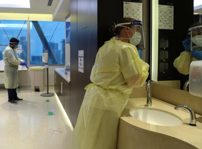 Members of medical staff put on protective equipment in a ward treating COVID-19 positive patients, amid the coronavirus disease (COVID-19) outbreak, at the Cleveland Clinic hospital in Abu Dhabi, United Arab Emirates, April 20, 2020. REUTERS/Christopher 