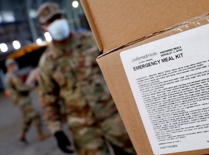 A U.S. Army National Guard soldier wears a protective face mask while loading a vehicle with food for delivery to residents in need at the Kingsbridge Armory which is being used as a temporary food distribution center during the outbreak of the coronaviru