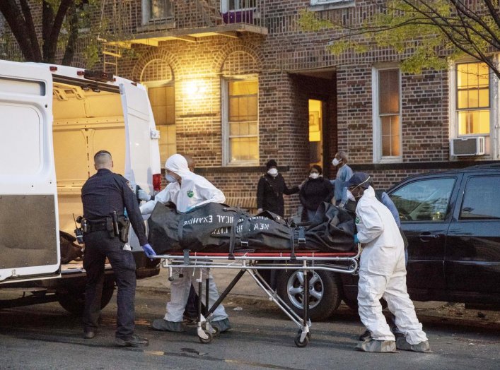 An officer from the New York Police Department helps workers carry a body out of a house amid the coronavirus disease (COVID-19) outbreak, in the Brooklyn borough of New York City, U.S., April 20, 2020. REUTERS/Lucas Jackson