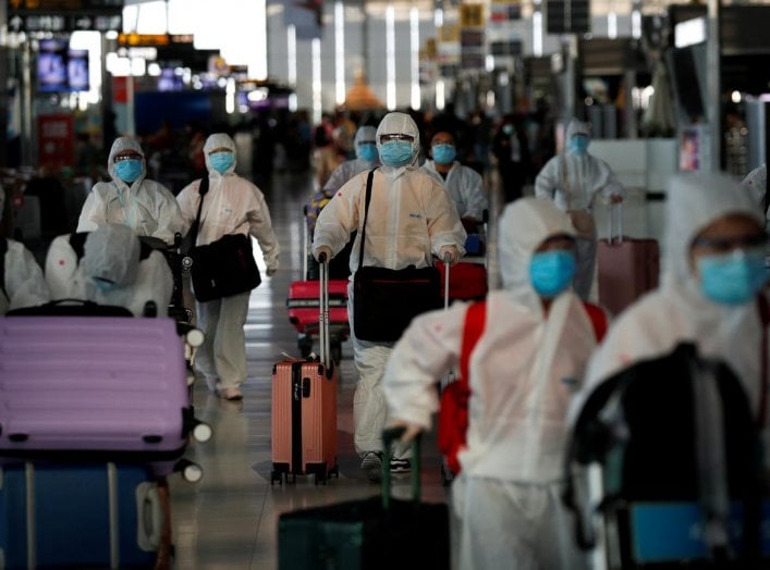 Chinese students living in Thailand wear protective suits as a measure of protection against the coronavirus disease (COVID-19) as they walk at the Suvarnabhumi Airport before boarding a repatriation flight, in Bangkok, Thailand April 21, 2020. REUTERS/Jo