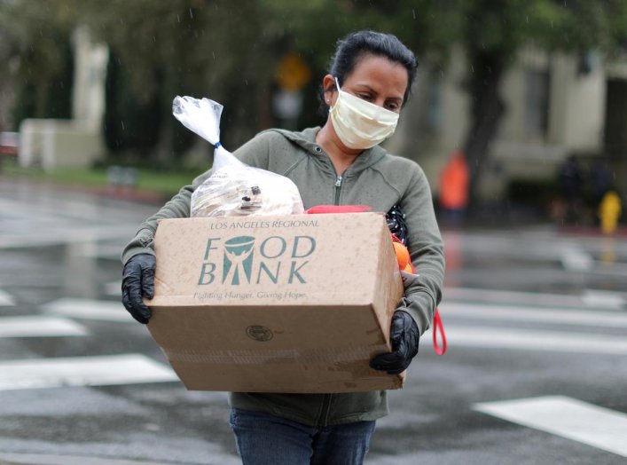 A woman carries away fresh food at a Los Angeles Regional Food Bank giveaway of 2,000 boxes of groceries, as the spread of the coronavirus disease (COVID-19) continues, in Los Angeles, California, U.S., April 9, 2020. REUTERS/Lucy Nicholson