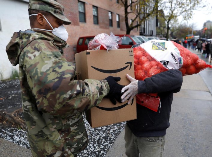 A U.S. Army National Guard soldier gives food to a man at a curbside food pantry for needy residents during the outbreak of the coronavirus disease (COVID-19) in the Brooklyn borough of New York City, New York, U.S., April 24, 2020. REUTERS/Mike Segar