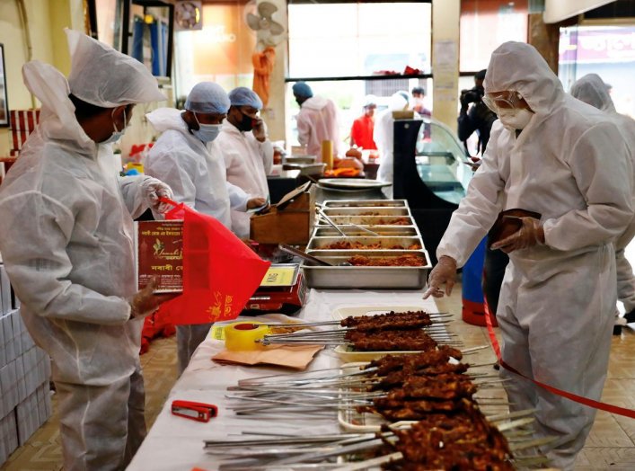 A man wears a protective suit as he purchases iftar meals from a restaurant during Ramadan, amid concerns over the coronavirus disease (COVID-19) outbreak in Dhaka, Bangladesh, April 29, 2020. REUTERS/Mohammad Ponir Hossain