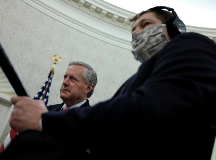 White House Acting Chief of Staff Mark Meadows listens next to a masked soundman and member of the news media during U.S. President Donald Trump's coronavirus response meeting with New Jersey Governor Phil Murphy in the Oval Office at the White House in W