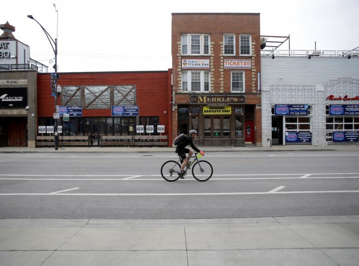 A bicyclist rides past closed businesses in the Wrigleyville neighborhood near the Chicago Cubs home stadium of Wrigley Field, which has been closed due to the coronavirus disease (COVID-19) restrictions in Chicago, Illinois, U.S. May 20, 2020. Picture ta