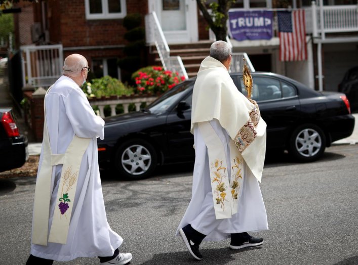 Deacons Paul Norman (R) and Robert Lavanco of Our Lady of Hope Catholic Church lead a procession called the Blessed Sacrament, to bring blessings to worshippers outside their homes while their church sanctuary is closed to them in the Queens borough of Ne