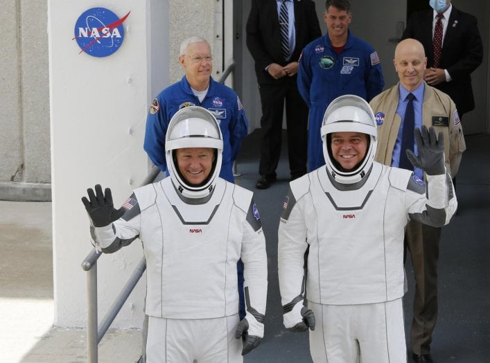 NASA astronauts Douglas Hurley and Robert Behnken wave as they head to Pad39A before the launch of a SpaceX Falcon 9 rocket and Crew Dragon spacecraft at the Kennedy Space Center, in Cape Canaveral, Florida, U.S., May 27, 2020. REUTERS/Joe Skipper