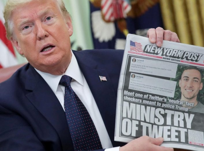 U.S. President Donald Trump holds up a front page of the New York Post as he speaks to reporters while discussing an executive order on social media companies in the Oval Office of the White House in Washington, U.S., May 28, 2020. REUTERS/Jonathan Ernst