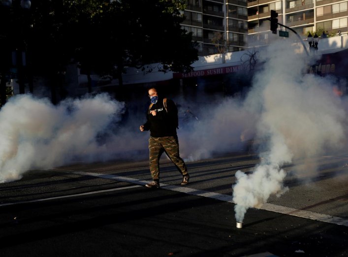 A demonstrator runs after police fired tear gas during a rally amid nationwide unrest following the death in Minneapolis police custody of George Floyd, in Oakland, California, U.S., June 1, 2020. REUTERS/Stephen Lam