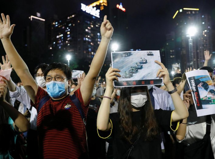 Protesters wearing protective face masks take part in a candlelight vigil to mark the 31st anniversary of the crackdown of pro-democracy protests at Beijing's Tiananmen Square in 1989, after police rejects a mass annual vigil on public health grounds, at 