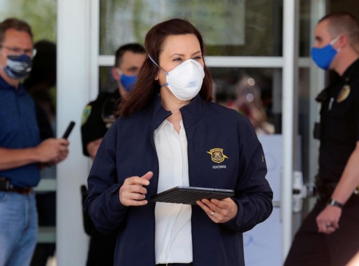 Michigan Governor Gretchen Whitmer wears a face mask as she arrives to address the media about the flooding along the Tittabawassee River, after several dams breached, in downtown Midland, Michigan U.S., May 20, 2020. REUTERS/Rebecca Cook