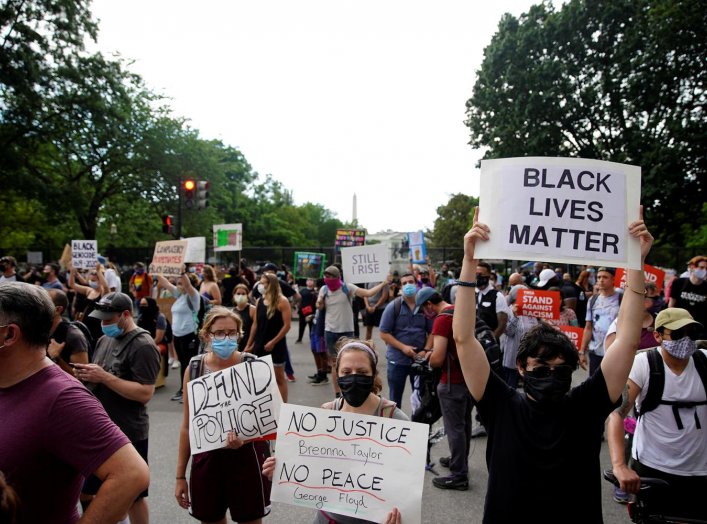 Demonstrators gather as they hold placards during a protest against the death in Minneapolis police custody of George Floyd, near the White House, in Washington, U.S., June 5, 2020. REUTERS/Eric Thayer