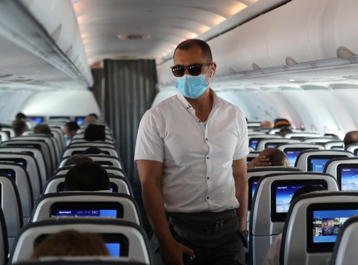 A traveller wears a protective face mask on a plane, following an outbreak of the coronavirus disease (COVID-19), at Cairo International Airport in Cairo, Egypt, June 18, 2020. REUTERS/Mohamed Abd El Ghany