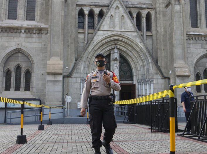 A policeman, part of a large-scale task force enforcing social restrictions amid the coronavirus disease (COVID-19) outbreak, walks with a face mask outside a church on the first day of its reopening, in Jakarta, Indonesia, July 12, 2020. REUTERS/Ajeng Di