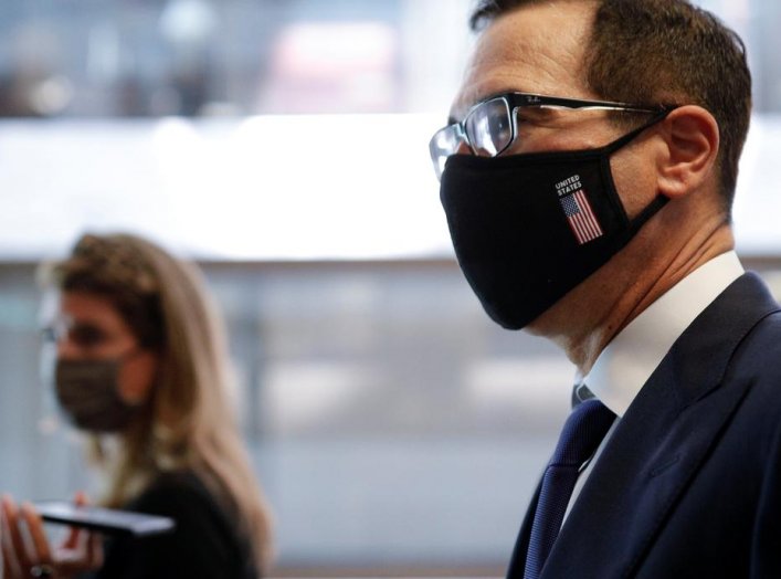 U.S. Treasury Secretary Steve Mnuchin, wearing a face mask, walks with news reporters, following a series of meetings with members of Congress on Capitol Hill in Washington, U.S. July 21, 2020. REUTERS/Tom Brenner