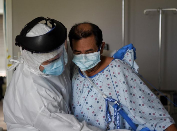 Fernando Olvera, 26, a medical school student, helps Efrain Guevara, 63, who has been hospitalised with COVID-19, get up from his hospital bed, at United Memorial Medical Center (UMMC), during the coronavirus disease (COVID-19) outbreak, in Houston, Texas