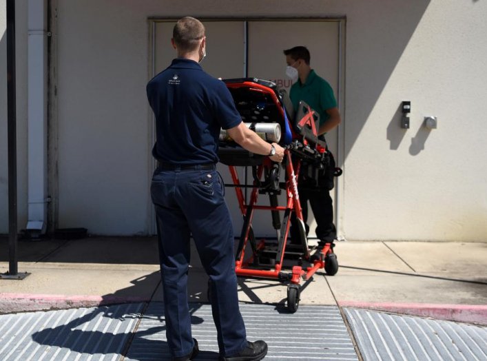 Orion EMS employees wheel a stretcher into the Houston Methodist Emergency Care Center at Kirby while wearing protective equipment to prevent the spread of the coronavirus disease (COVID-19) in Houston, Texas, U.S., August 19, 2020. REUTERS/Callaghan O'Ha