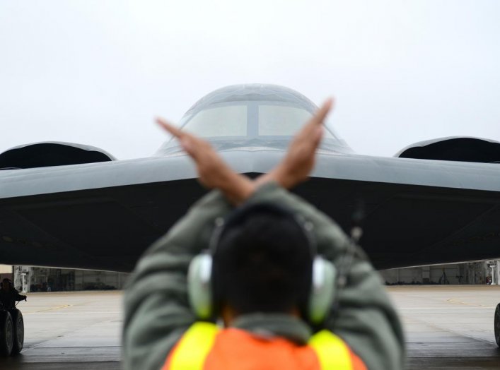 A crew chief from Whiteman Air Force Base, Mo., marshals in a B-2 Spirit stealth bomber at Whiteman Air Force Base, Mo., Jan 19, 2017 (U.S. Air Force photo by Senior Airman Joel Pfiester)