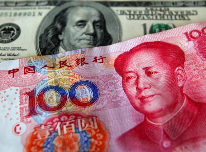 FILE PHOTO: A yuan banknote is displayed next to a U.S. dollar banknote (back) for the photographer at a money changer inside the Taoyuan International Airport March 18, 2010. REUTERS/Nicky Loh/File Photo