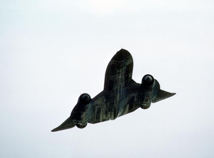 An underside view of an SR-71 Blackbird strategic reconnaissance aircraft in flight at an undisclosed location.