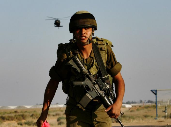 An Israeli soldier watches a chopper land on a military area in Kerem Shalom at the border with Gaza June 28, 2006. Israel fired artillery shells into the northern Gaza Strip on Wednesday as troops and tanks prepared to widen an offensive aimed at forcing