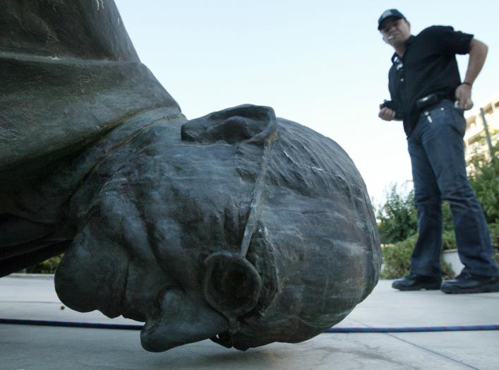 A man walks past the statue of U.S. President Harry S. Truman in Athens, July 25, 2006, which was pulled down by Greek leftists in a move harking back to the U.S. invasion of Iraq as part of an anti-war demonstration against the Israeli bombing of Lebanon