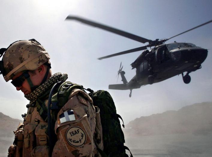 A Canadian soldier from the NATO-led coalition force turns his back away from a dust cloud kicked up by a Blackhawk helicopter taking off from the forward operating base of Ma'sum Ghar, Afghanistan, July 1, 2007. REUTERS/ Finbarr O'Reilly (AFGHANISTAN)
