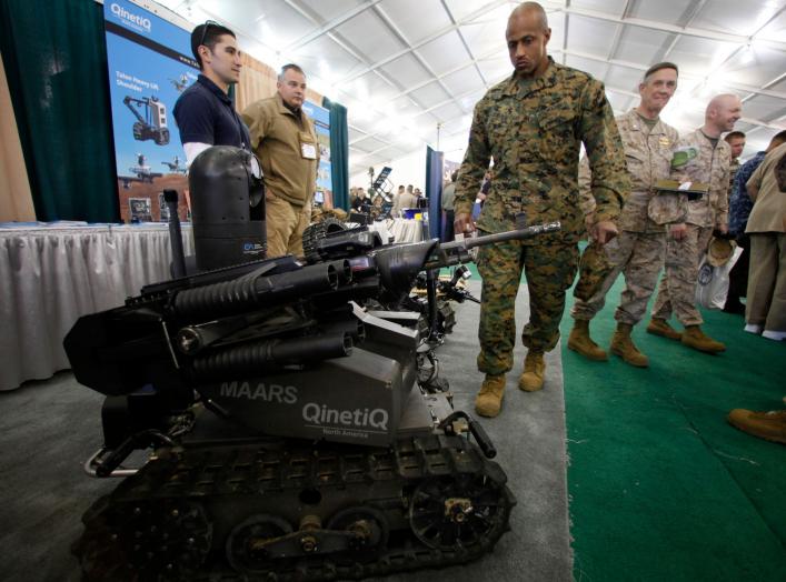 A soldier looks at a MAARS (Modular Advanced Armed Robotic System) robot at the Marine West Military Expo at Camp Pendleton, California February 1, 2012. The expo is one of the year's largest annual display of new military equipment. REUTERS/Mike Blake (U
