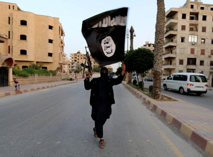A member loyal to the Islamic State in Iraq and the Levant (ISIL) waves an ISIL flag in Raqqa June 29, 2014. The offshoot of al Qaeda which has captured swathes of territory in Iraq and Syria has declared itself an Islamic "Caliphate" and called on factio