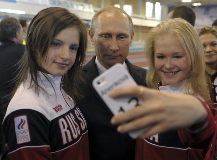 Russian President Vladimir Putin (C) poses for a picture with youths who took part in the Nanjing 2014 Youth Olympic Games, as he visits a local Olympic youth sports school in Cheboksary, October 9, 2014. REUTERS/Alexei Druzhinin/RIA Novosti/Kremlin 