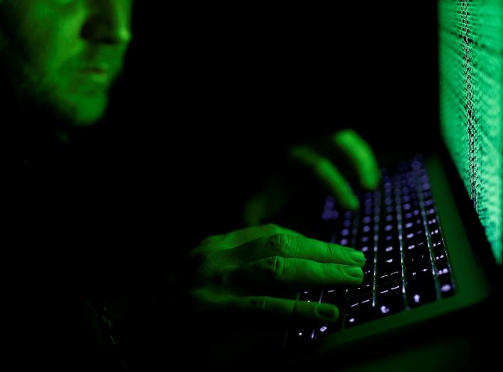 A man types on a computer keyboard in front of the displayed cyber code in this illustration picture taken on March 1, 2017. REUTERS/Kacper Pempel/Illustration